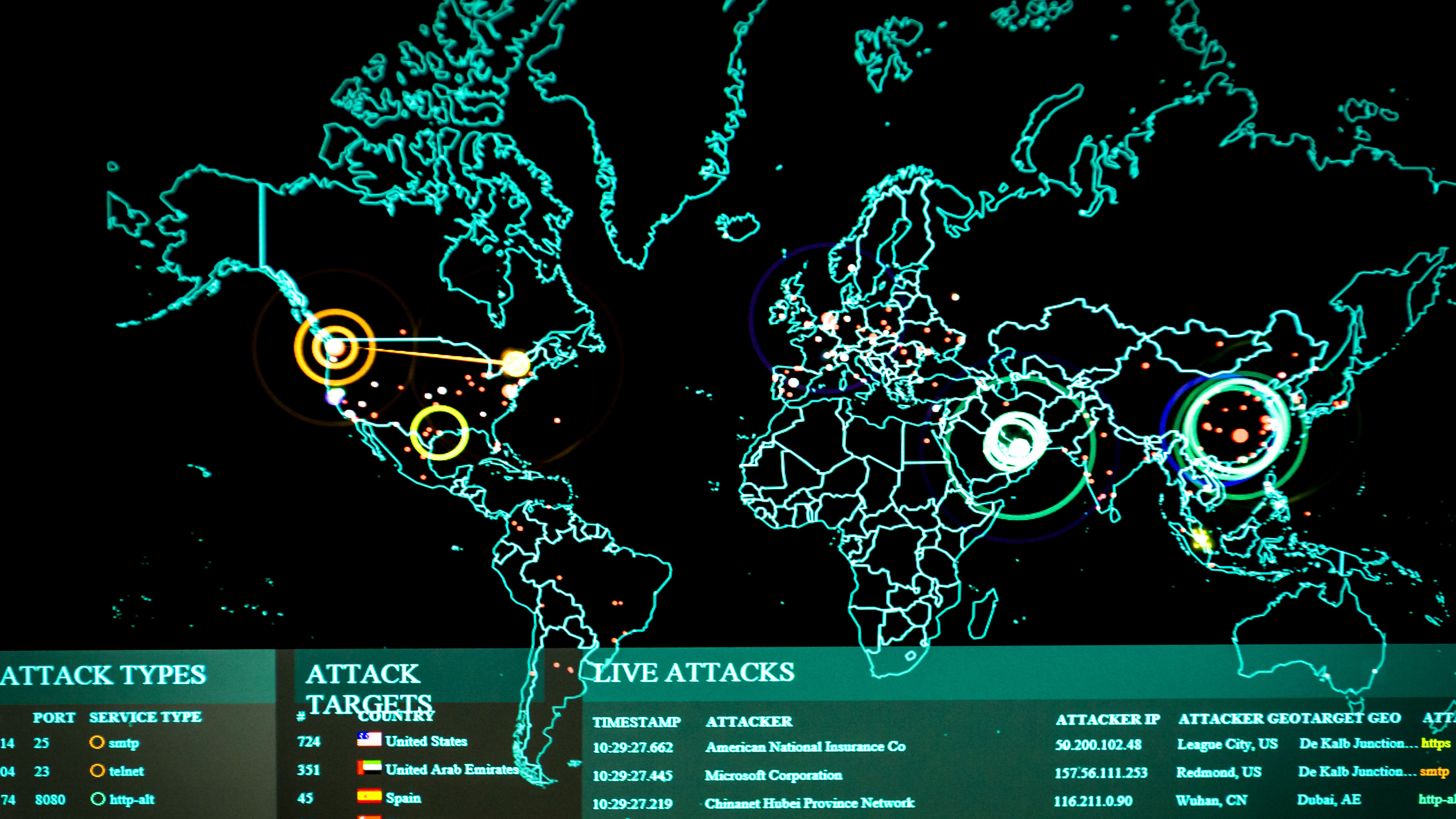 Cyber analyst hands at keyboard with threat map